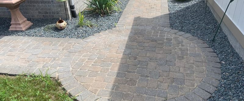 Completed landscape bed and lawn along a residential walkway.